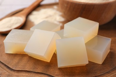 Photo of Agar-agar jelly cubes on wooden board, closeup