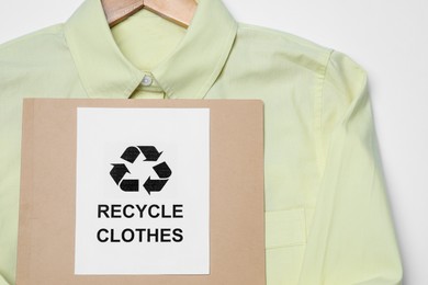 Shirt and card with recycling symbol on white background, closeup