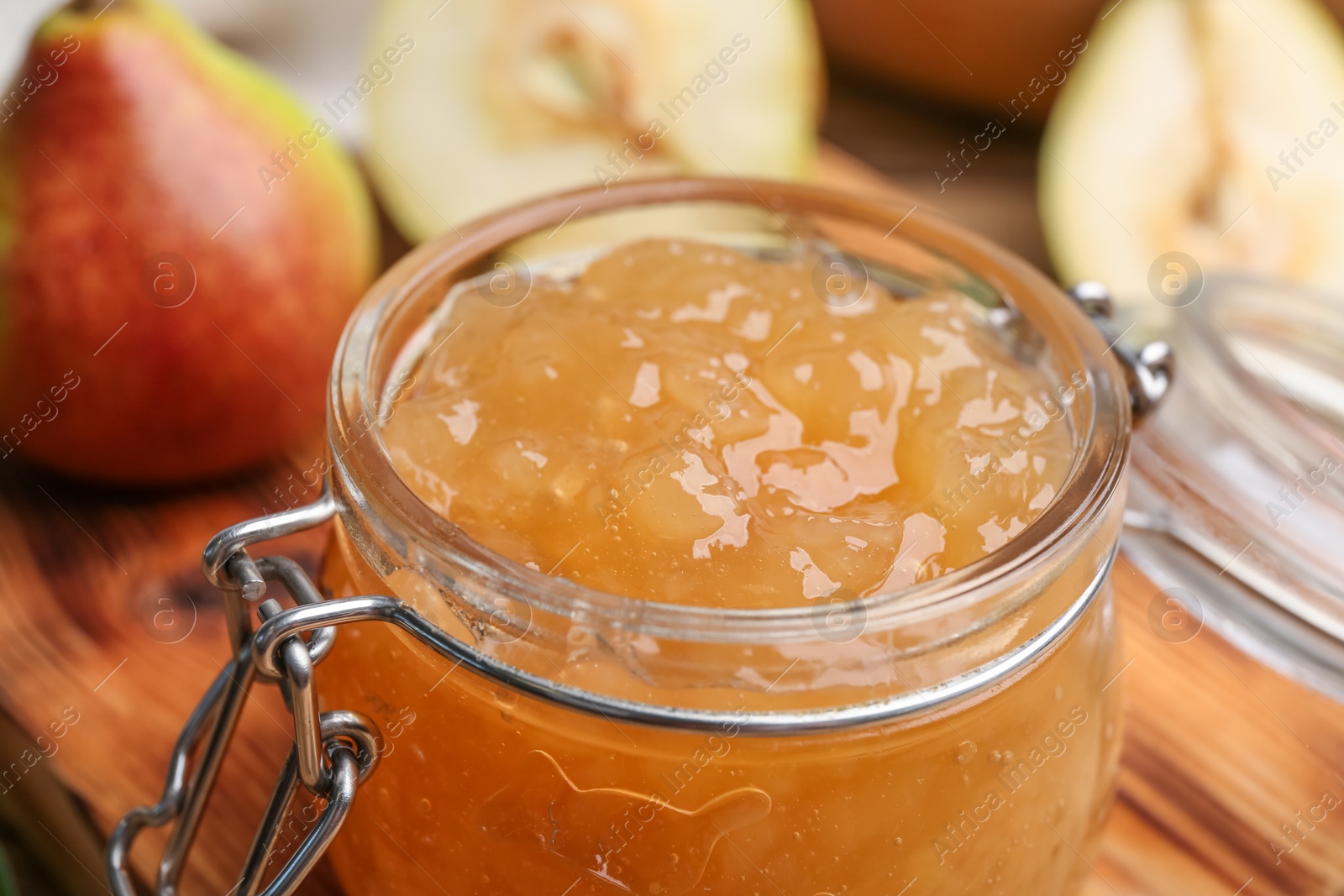 Photo of Delicious pear jam in glass jar, closeup