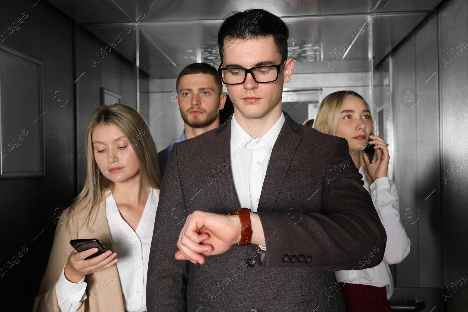 Photo of Group of office workers in modern elevator