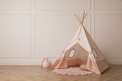 Photo of Cute child room interior with play tent near white wall, space for text