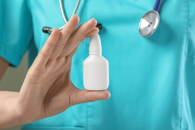 Photo of Woman holding nasal spray bottle, closeup view