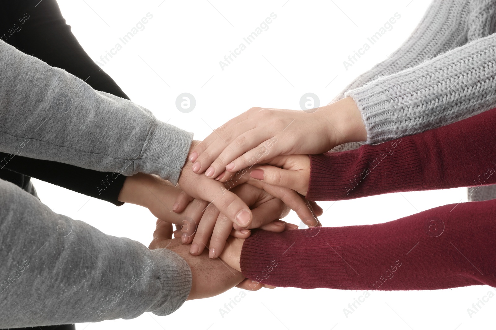 Photo of Young people putting their hands together on white background, closeup