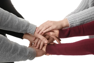 Photo of Young people putting their hands together on white background, closeup