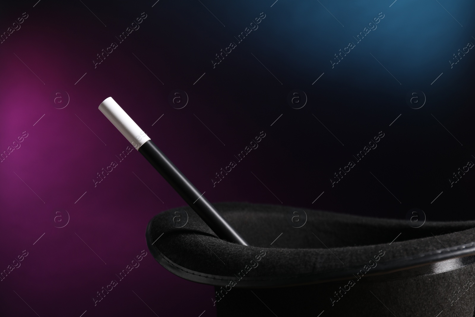 Photo of Magician's hat and wand on dark background, closeup