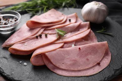 Photo of Tasty ham with rosemary, garlic and peppercorns on table, closeup