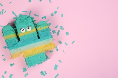 Bright cactus pinata and confetti on pink background, flat lay. Space for text