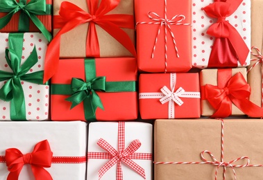 Photo of Beautifully wrapped gift boxes as background, closeup