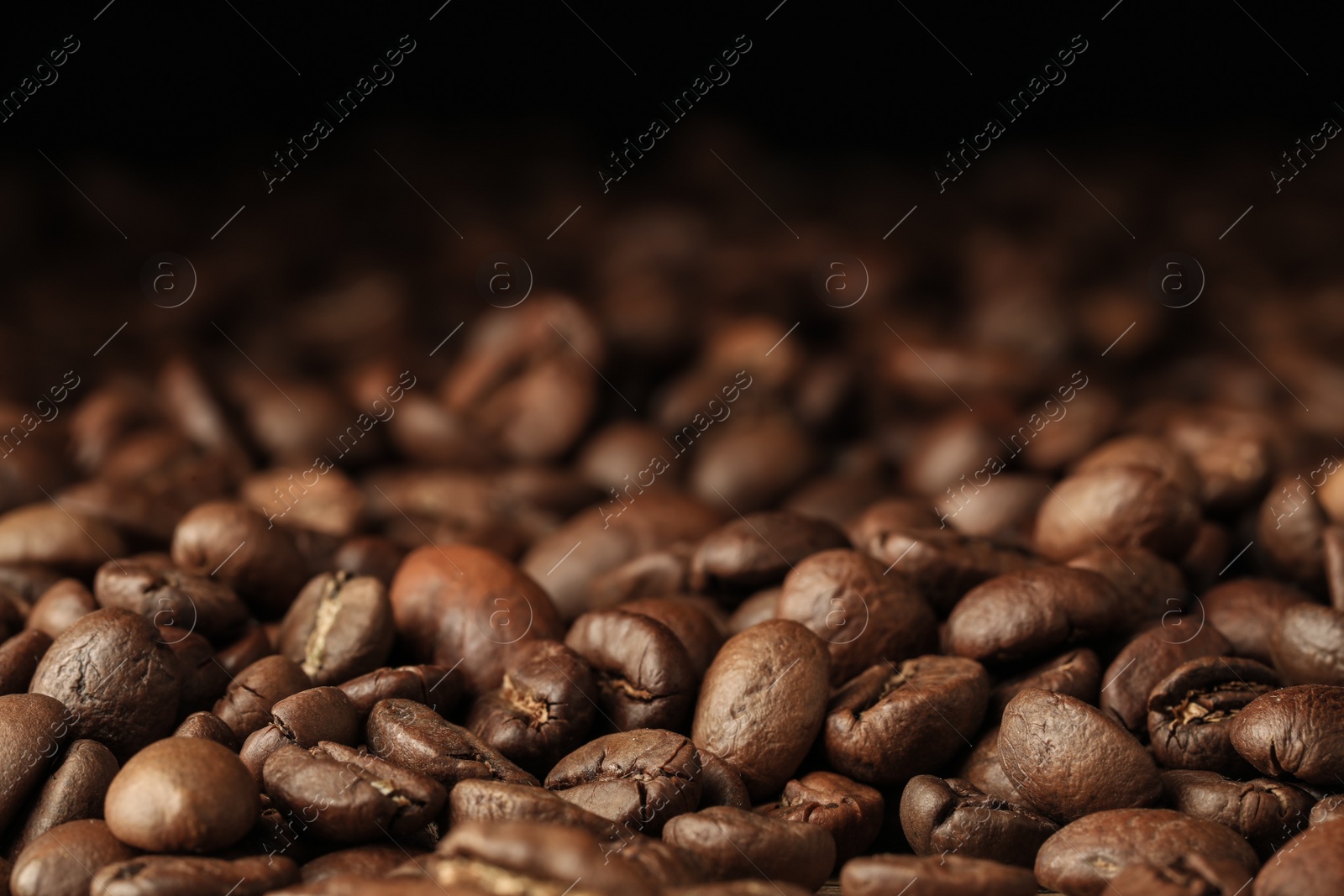 Photo of Heap of aromatic roasted coffee beans, closeup