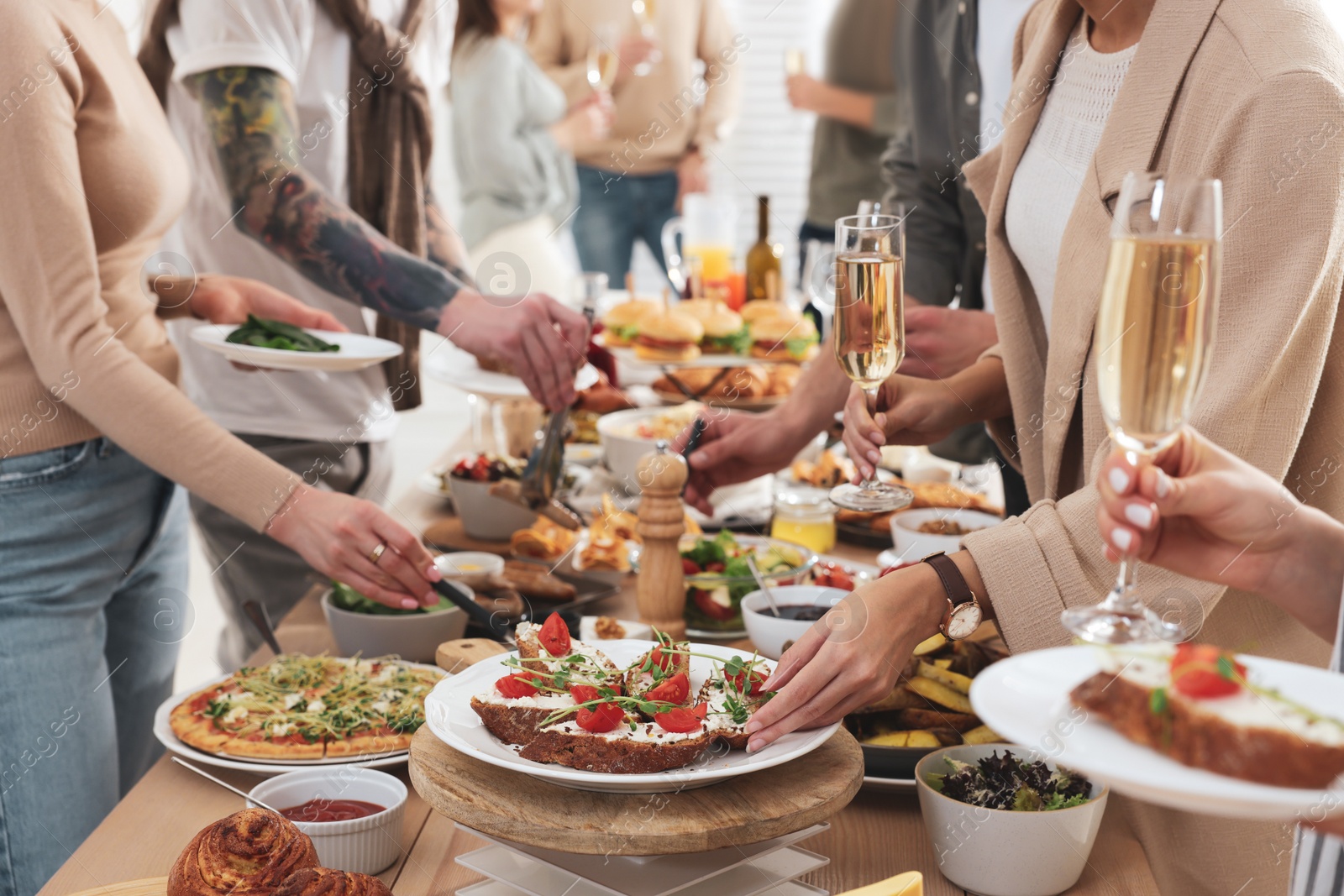 Photo of People near buffet table with food indoors, closeup. Brunch setting