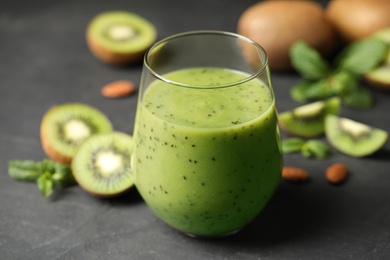 Delicious kiwi smoothie and fresh fruits on grey table