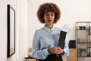 Notary with clipboard and pen in office