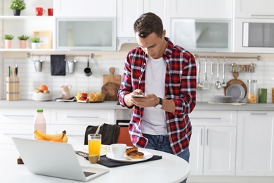 Photo of Food blogger taking photo of breakfast in kitchen