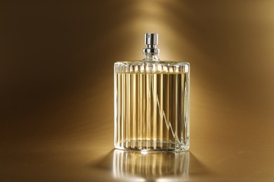 Luxury women's perfume. Sunlit glass bottle on golden background