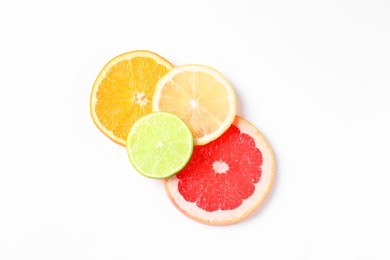 Slices of fresh ripe citrus fruits on white background, flat lay