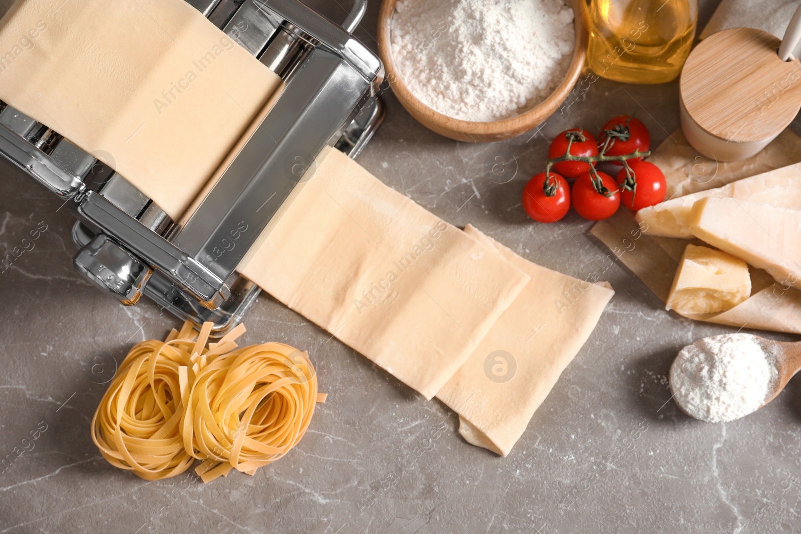 Photo of Pasta maker with dough and products on table, top view