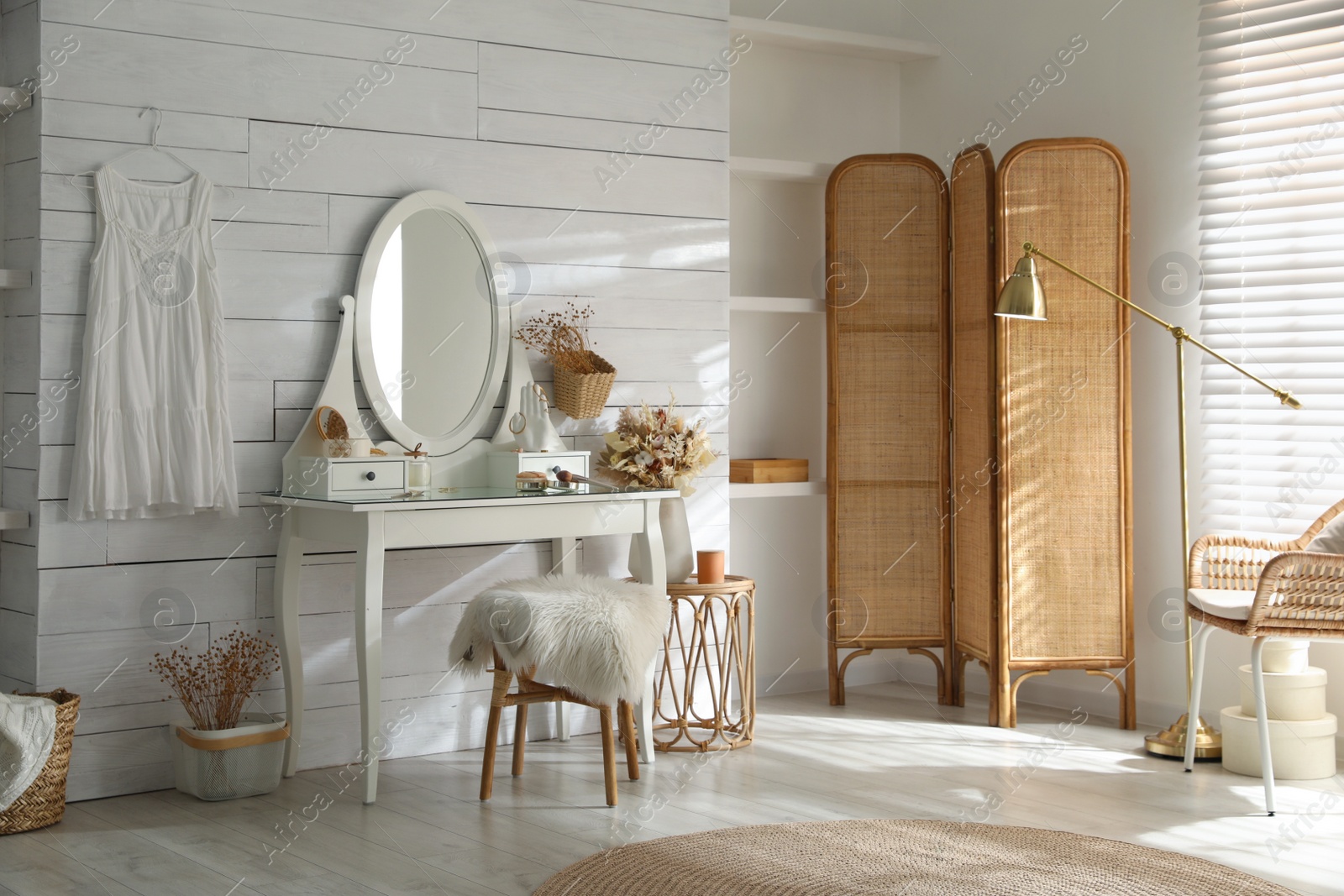 Photo of Wooden dressing table with decorative elements and makeup products in room. Interior design