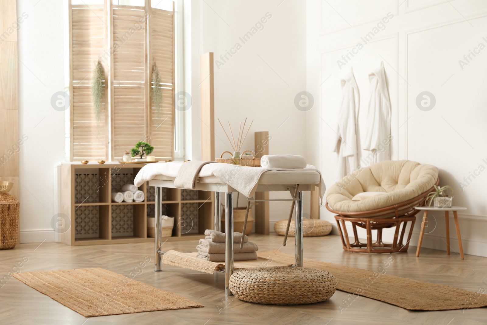 Photo of Stylish massage room interior with spa table in salon