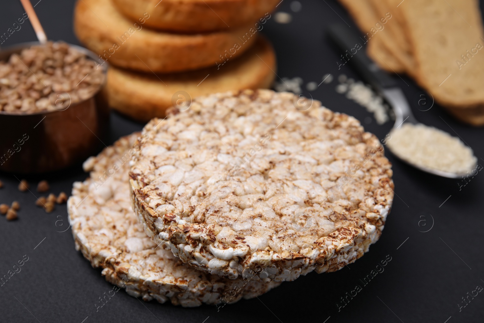 Photo of Rice cakes and rusks on black table, closeup