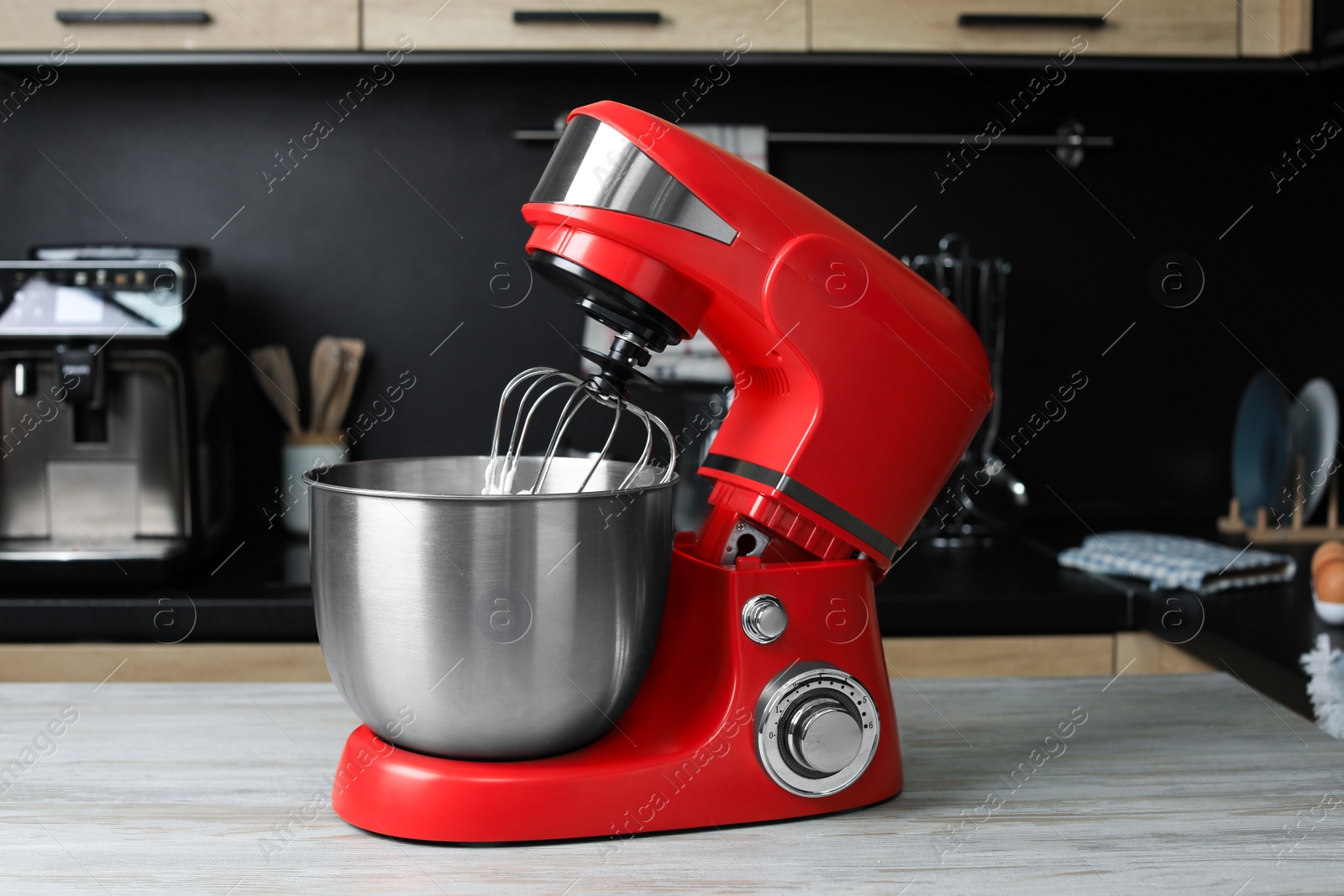 Photo of Modern stand mixer on wooden table in kitchen. Home appliance