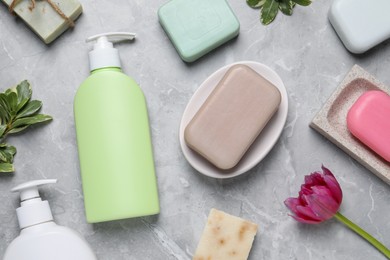 Photo of Flat lay composition with many different soap bars and bottle dispensers on light grey table