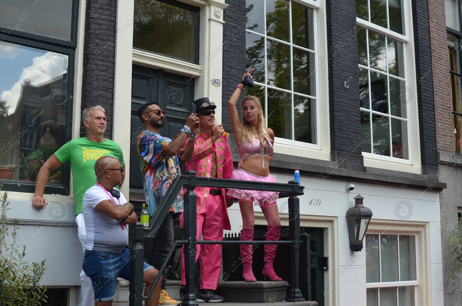 Photo of AMSTERDAM, NETHERLANDS - AUGUST 06, 2022: Many people near building at LGBT pride parade on sunny day