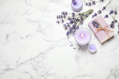 Photo of Cosmetic products and lavender flowers on white marble table, flat lay. Space for text