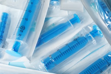 Photo of Packed disposable syringes with needles as background, above  view