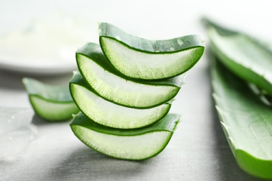 Fresh sliced aloe vera leaves on light background