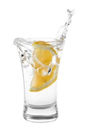 Vodka splashing out of shot glass with lemon on white background