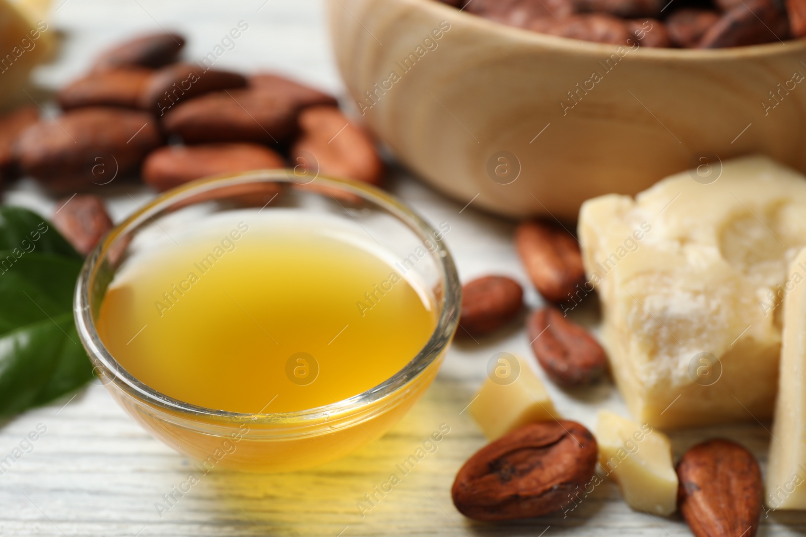 Photo of Organic cocoa butter on white wooden table, closeup