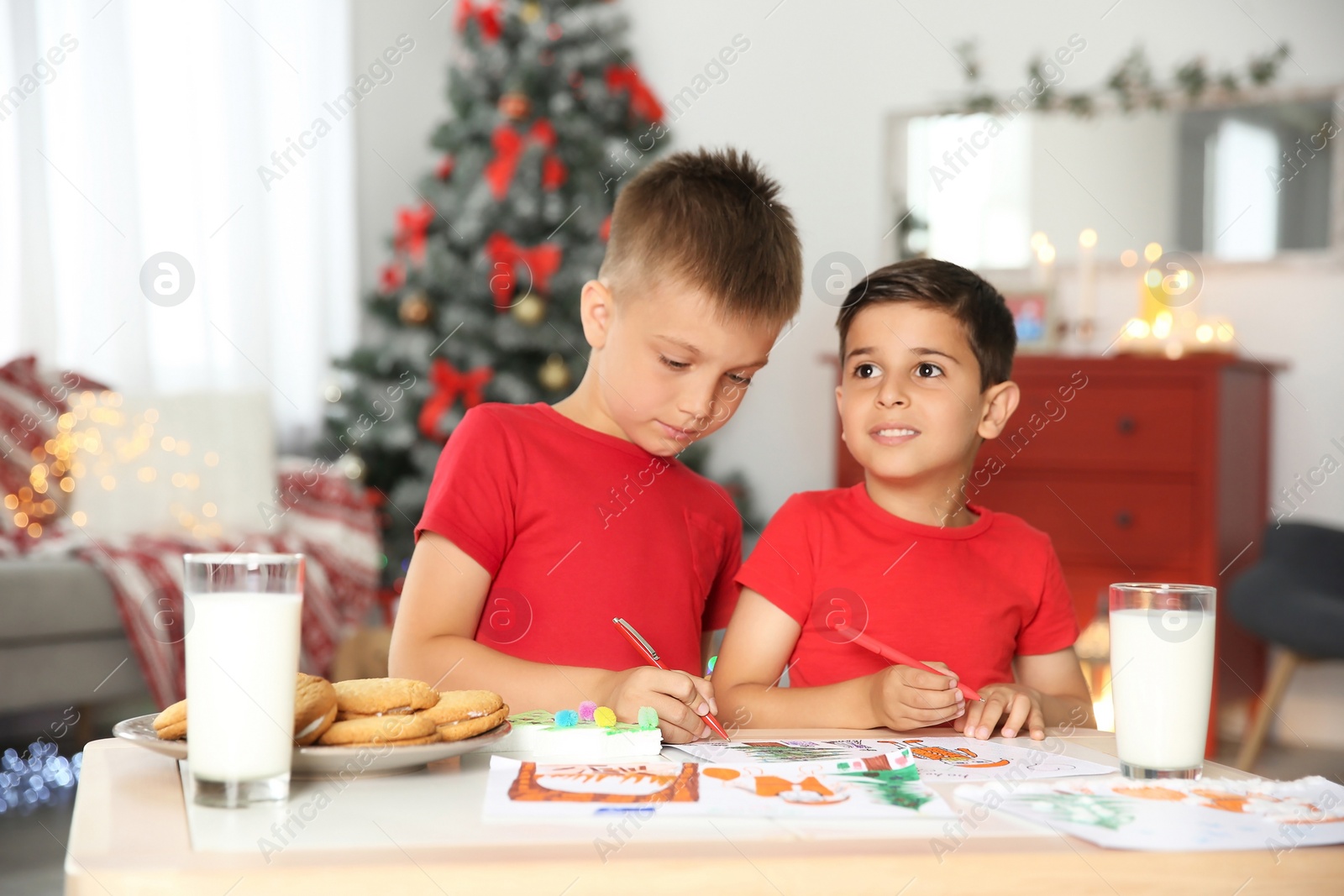 Photo of Little children drawing picture at home. Christmas celebration