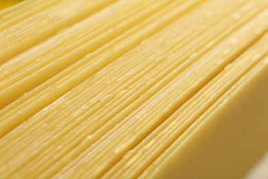 Photo of Pile of dry lasagna sheets as background, closeup