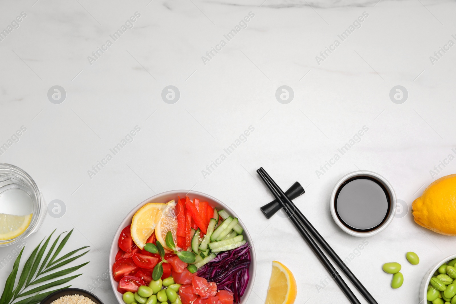 Photo of Poke bowl with salmon, edamame beans and vegetables on white marble table, flat lay. Space for text