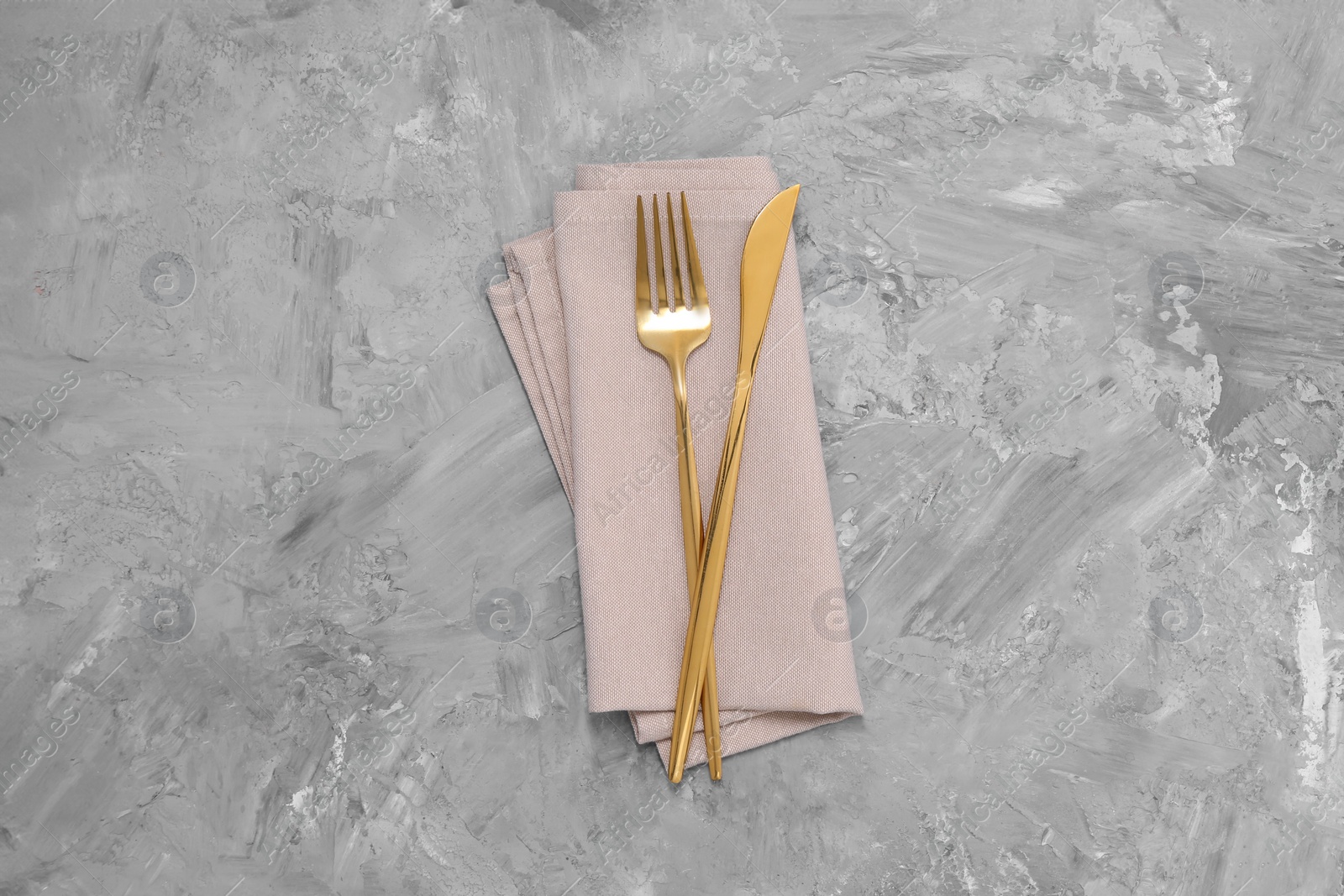 Photo of Beautiful cutlery set and kitchen towel on grey table, top view