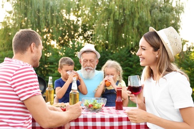 Photo of Happy family having barbecue in park on sunny day