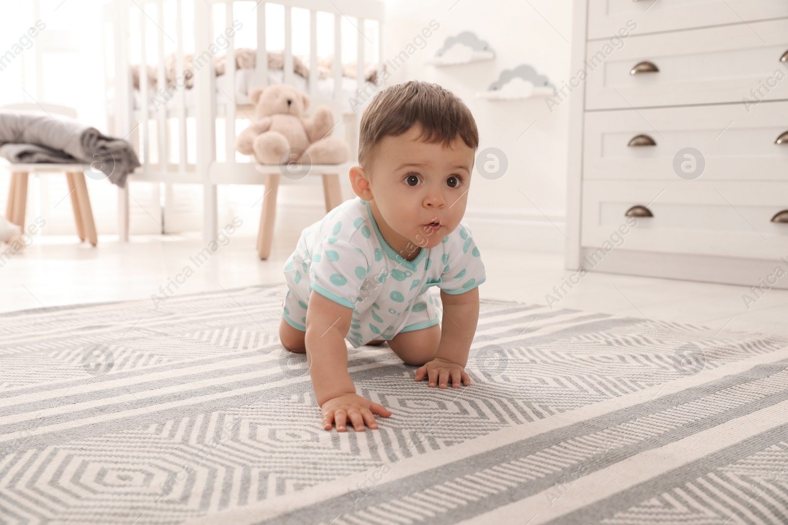 Photo of Cute baby crawling on floor at home