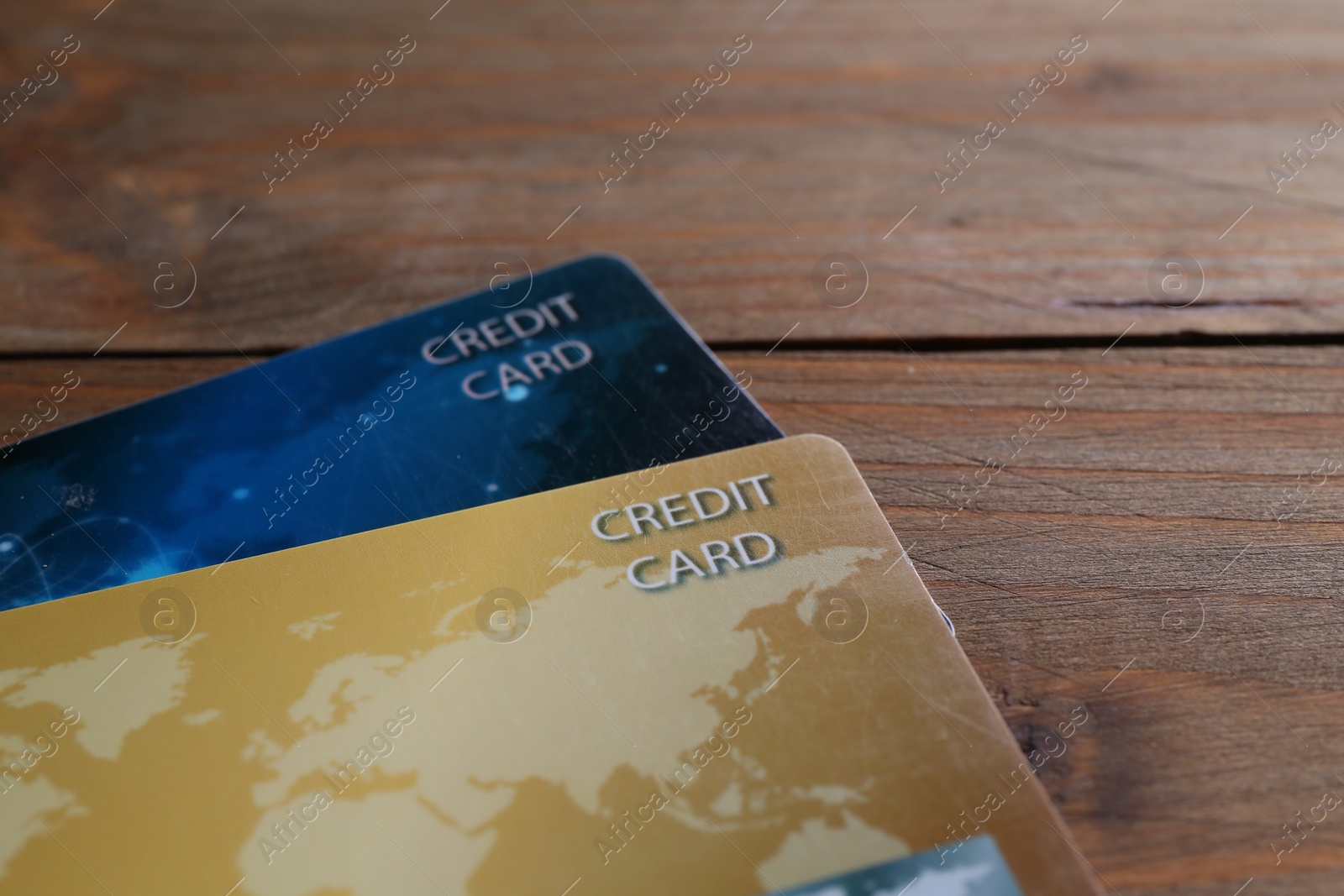 Photo of Two credit cards on wooden table, closeup