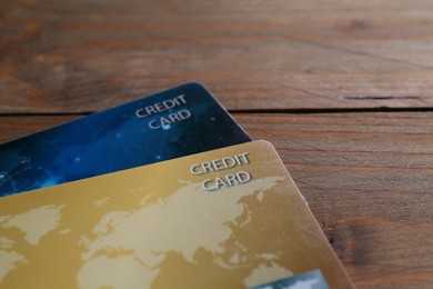 Photo of Two credit cards on wooden table, closeup