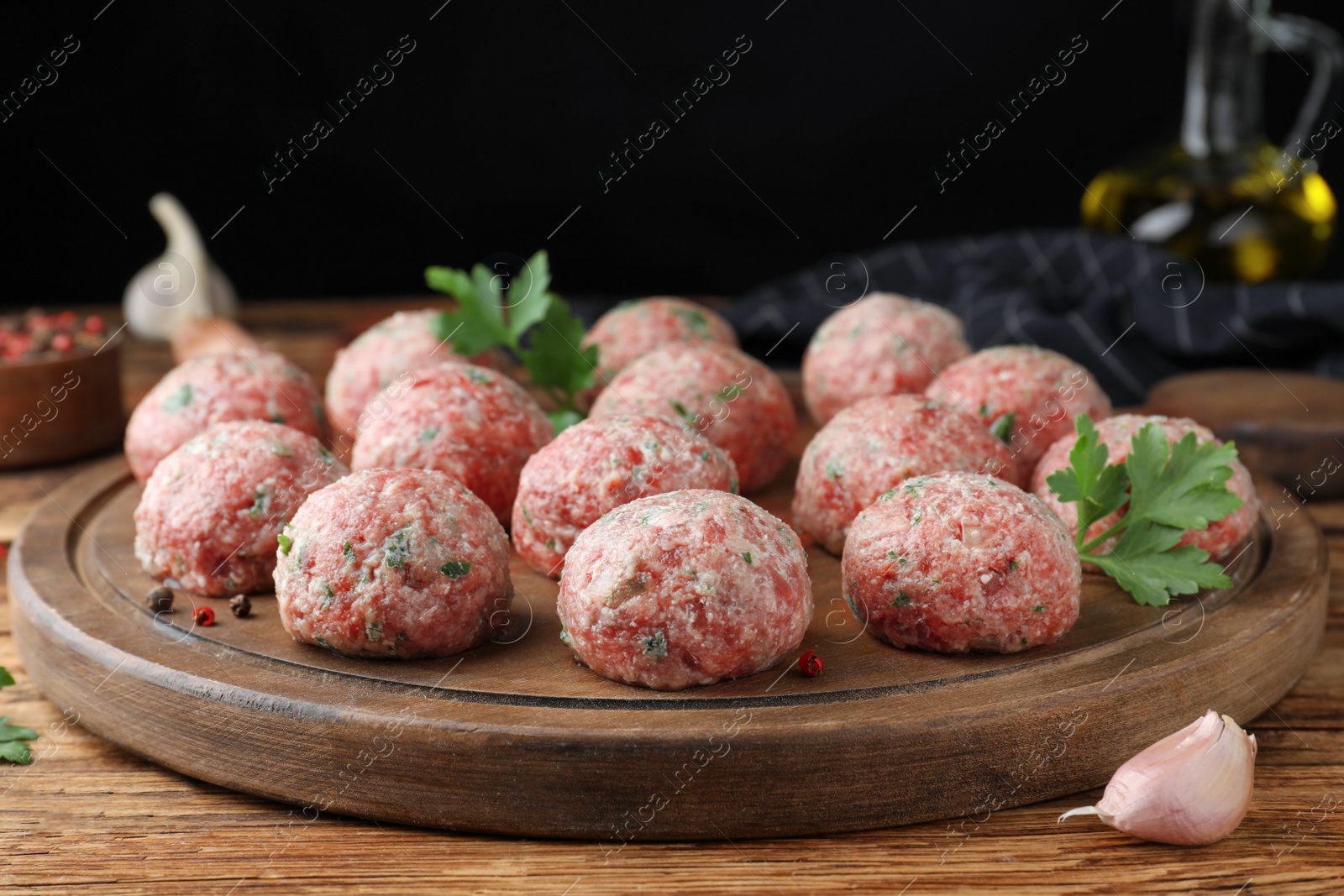 Photo of Many fresh raw meatballs on wooden table