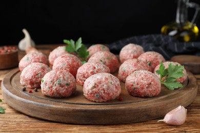 Photo of Many fresh raw meatballs on wooden table