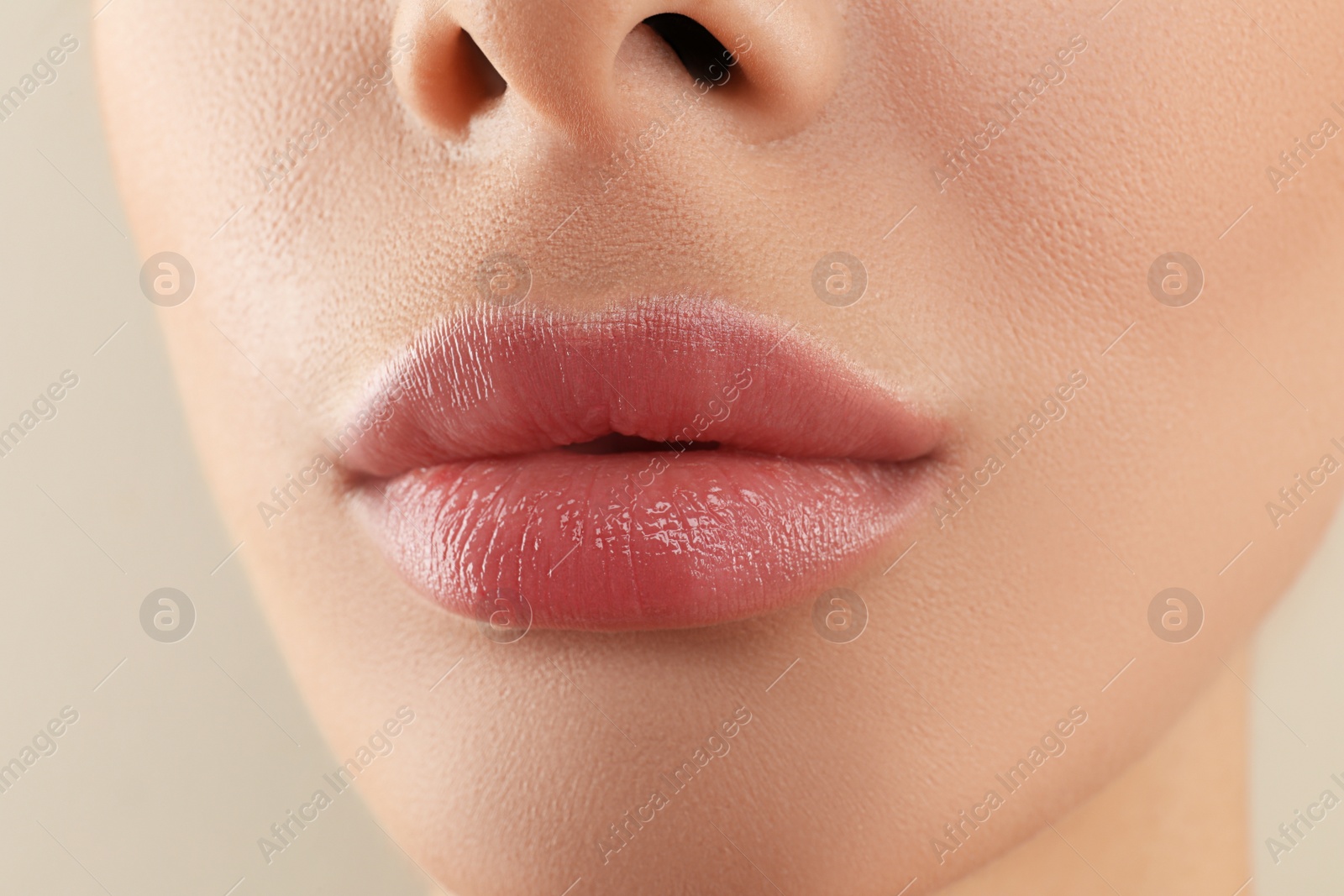 Photo of Woman with beautiful full lips on beige background, closeup