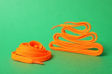 Photo of Long orange shoe laces on green background