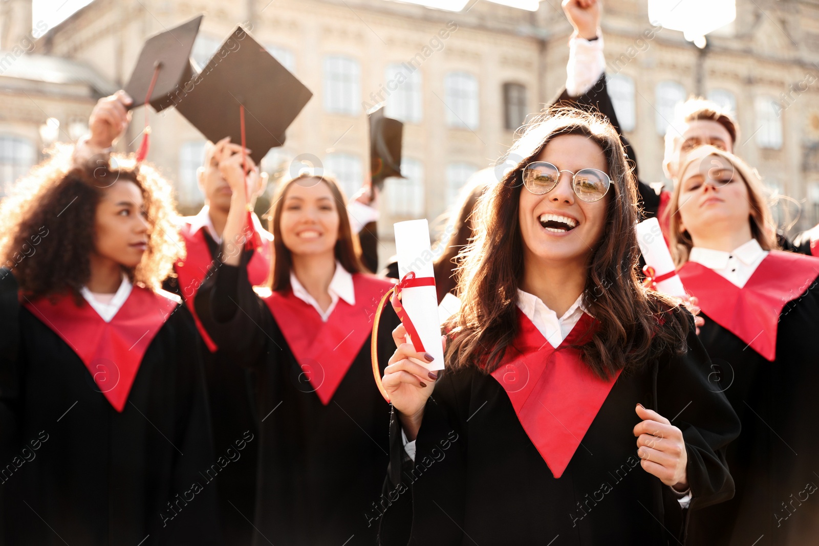 Photo of Group of happy students outdoors. Graduation ceremony