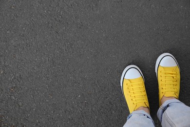 Photo of Woman standing on asphalt, top view. Space for text