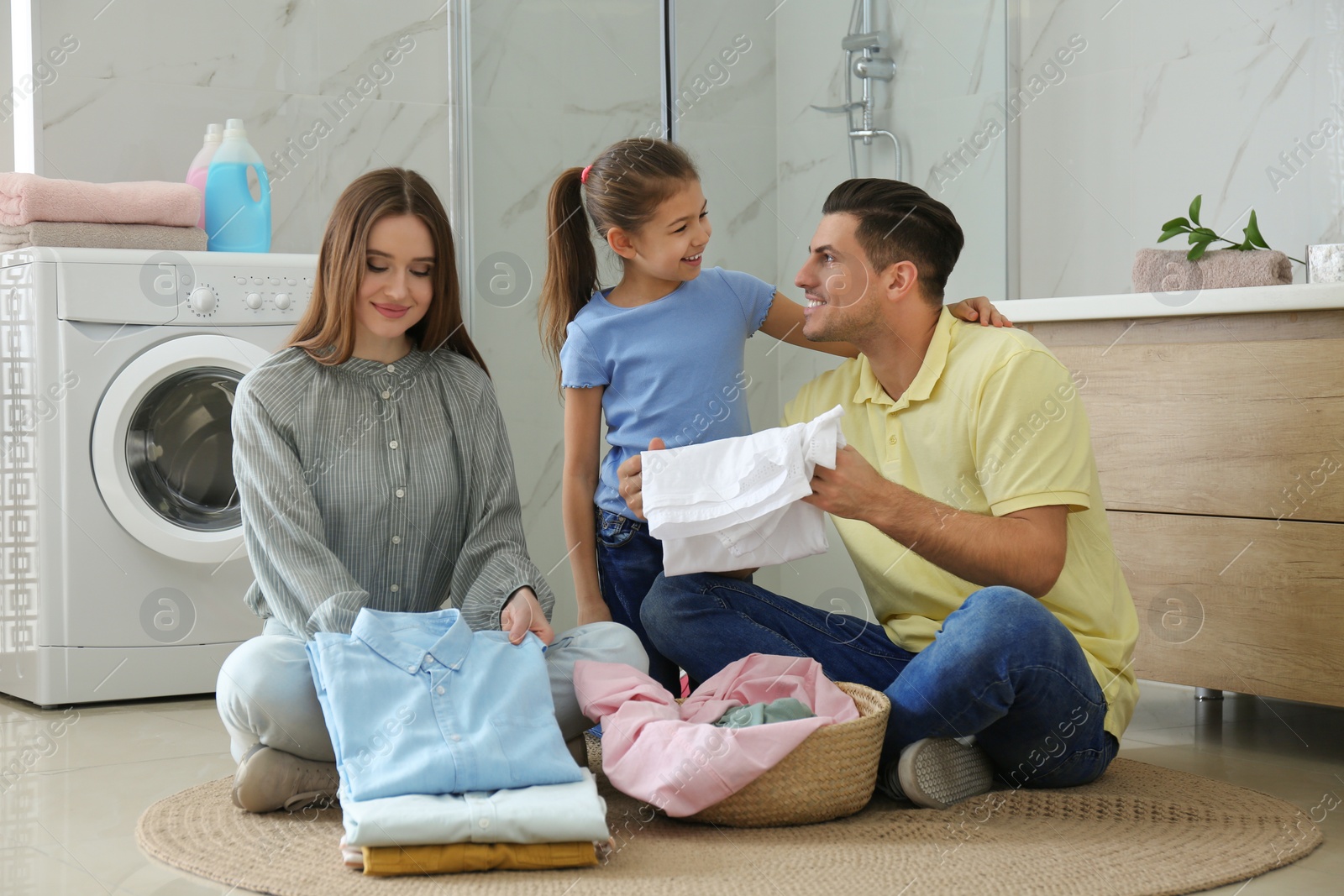 Photo of Happy family with clean laundry in bathroom