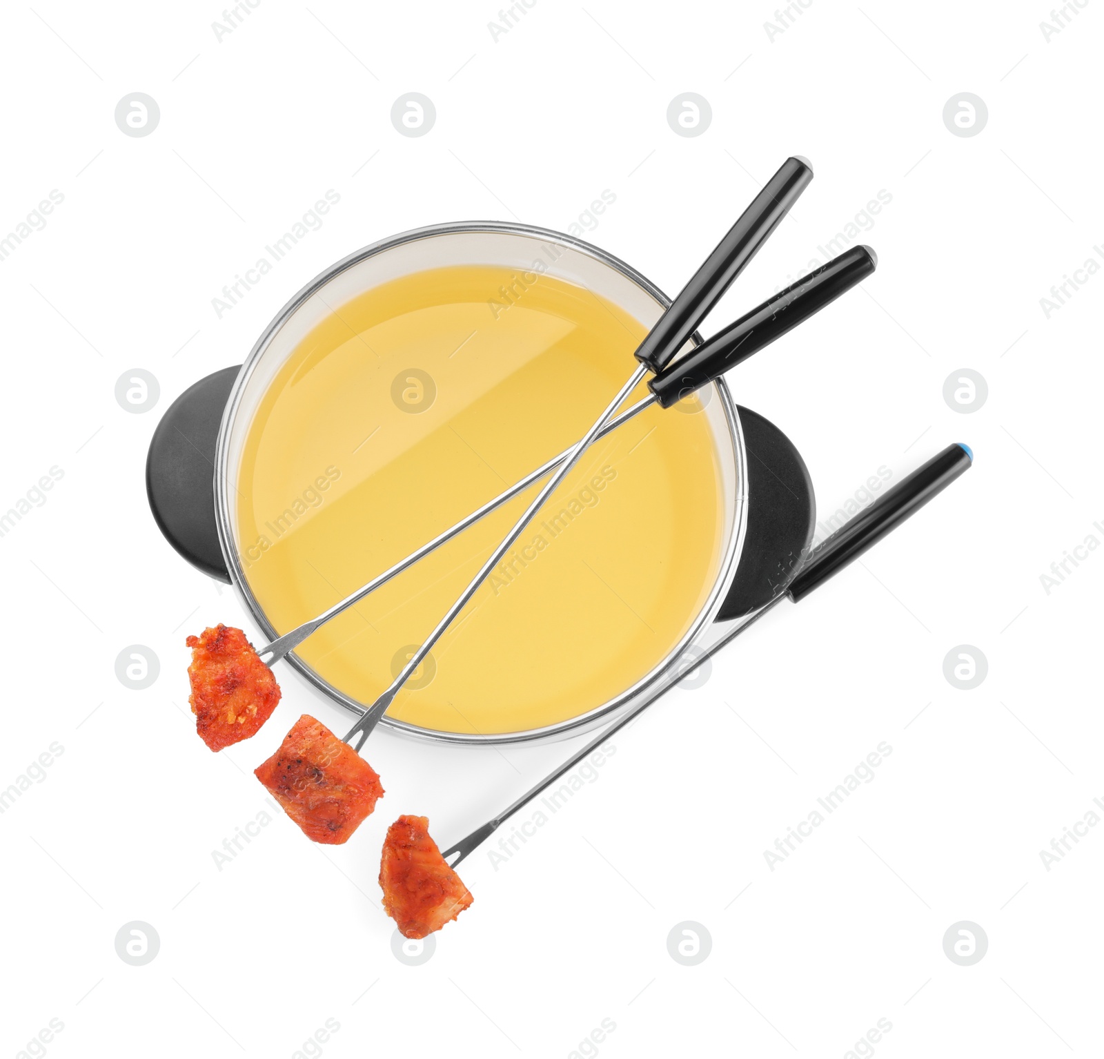 Photo of Oil in fondue pot and forks with fried meat pieces isolated on white, top view