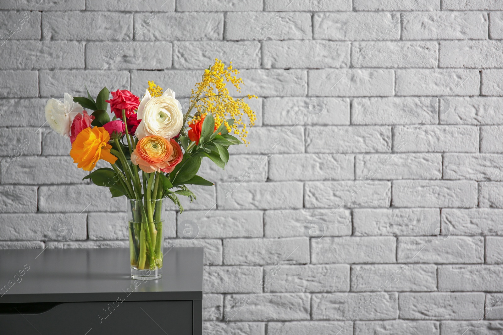 Photo of Vase with beautiful ranunculus flowers indoors