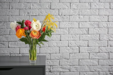 Photo of Vase with beautiful ranunculus flowers indoors