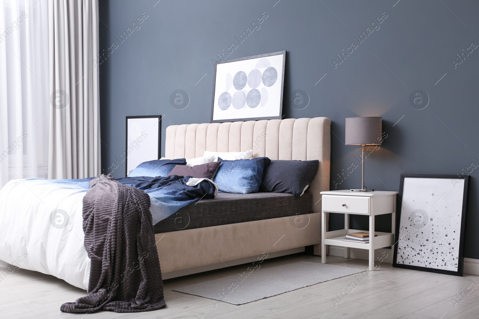 Photo of Comfortable bed with pillows and soft blanket in room. Stylish interior design